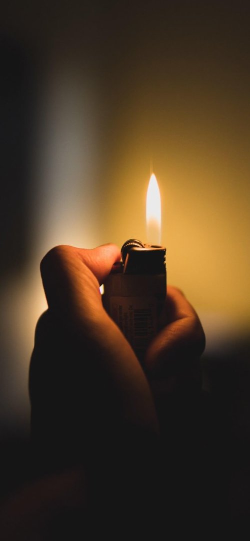 Hand Holding Lit Lighter - dark Wallpaper